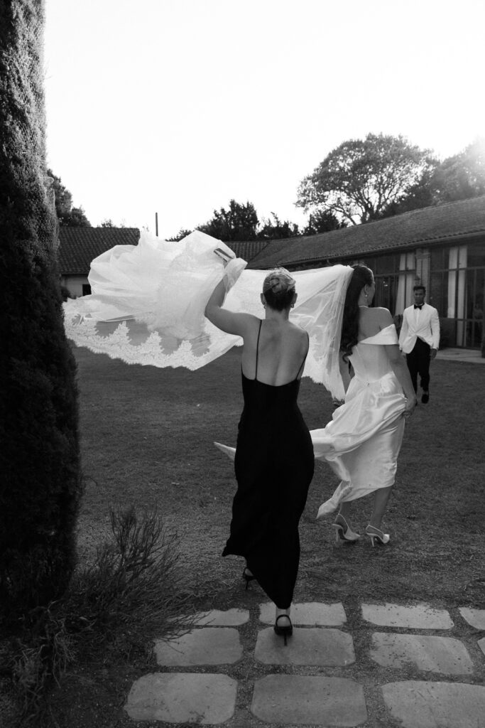 Bridesmaid adjusting the bride's veil on the wedding day at a destination wedding in Provence, south of France