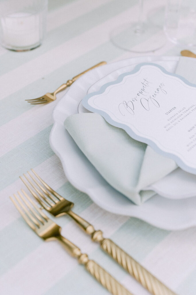 Elegant wedding table setting with gold cutlery, linen napkin and menu card at a reception in Provence, south of France