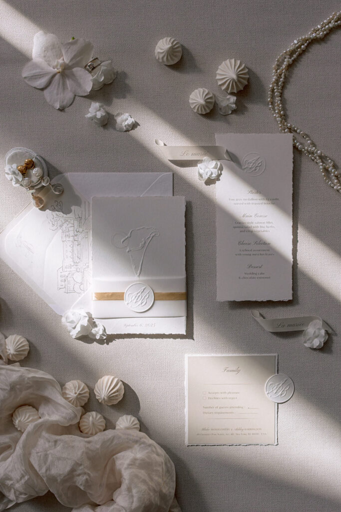 Editorial flatlay of wedding stationery with wax seals, menu cards and meringues for a destination wedding in Provence, south of France