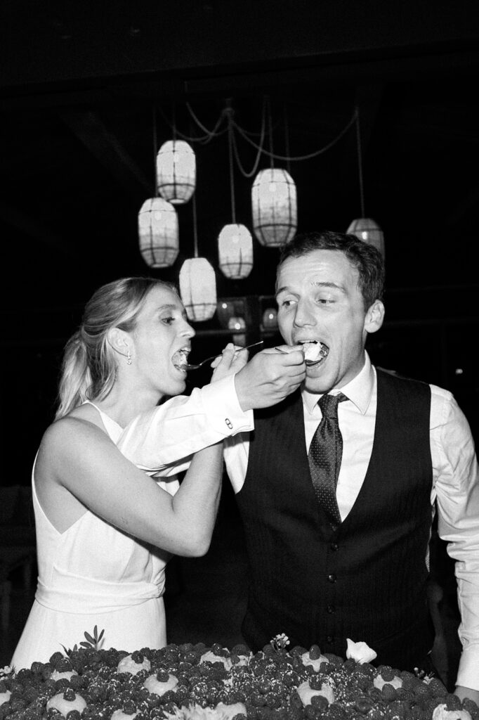 Black and white photo of the couple sharing cake at their wedding reception in Provence, south of France